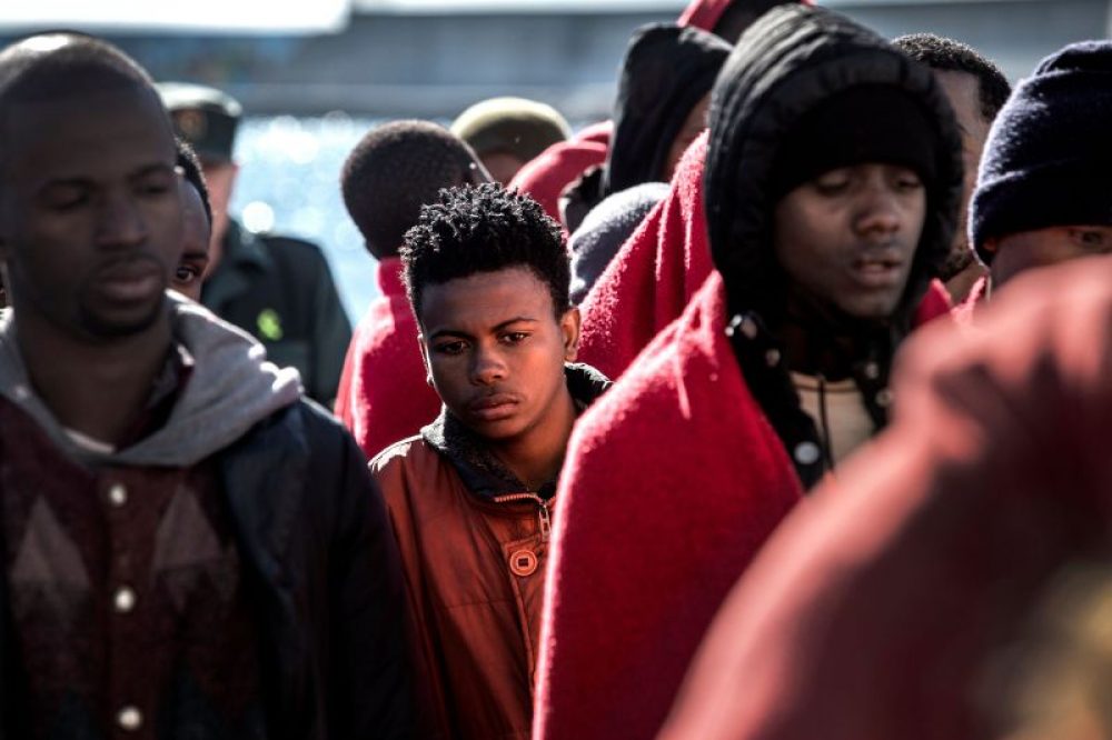 Migrantes esperando ser atendidos por la Cruz Roja en Motril